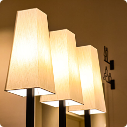 3 abat-jour en tissu tendu montrant comment le travail de la main transforme un simple support en luminaire élégant.